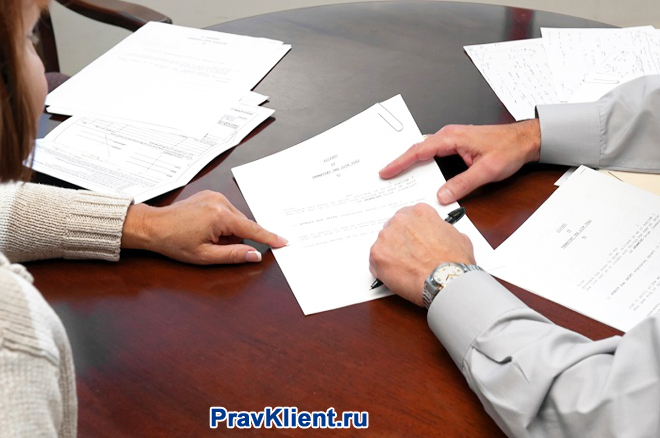 Бизнес-партнеры подписывают документацию за столом переговоров