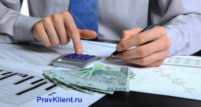Мужчина считает на калькуляторе денежные купюры
