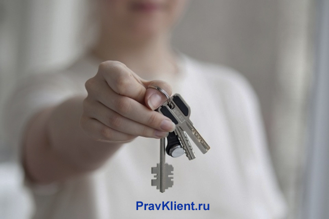Девушка держит в руке связку ключей
