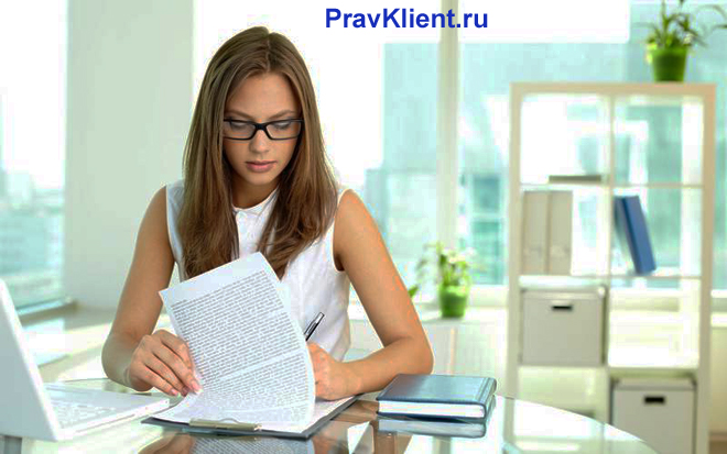 Девушка читает в офисе бумаги