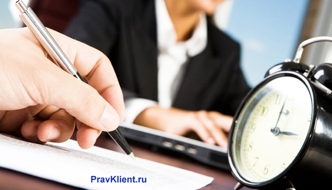 Мужчина пишет заявление, рядом стоит будильник