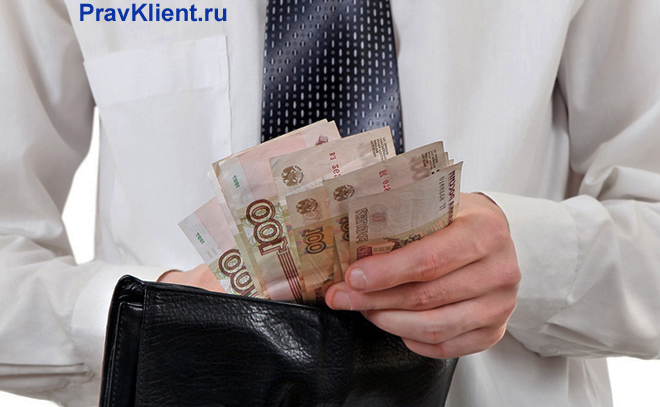 Офисный работник считает в руках деньги