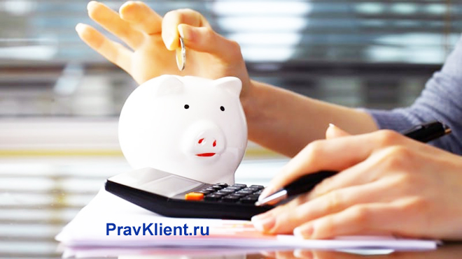 Девушка откладывает монеты в копилку и считает на калькуляторе