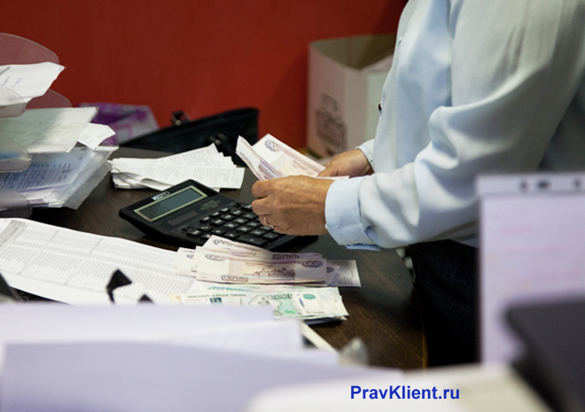 Мужчина пересчитывает в руках деньги