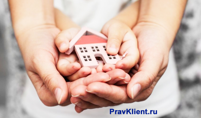 Семья держит в руках фигурку дома