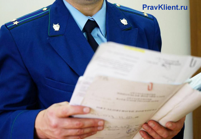 Сотрудник прокуратуры читает документы