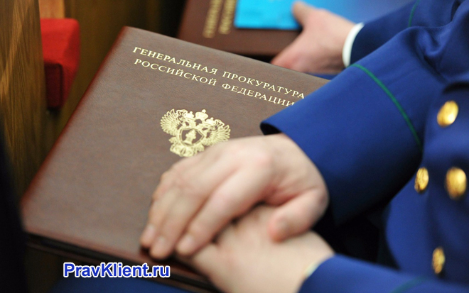 Прокурор держит в руке папку