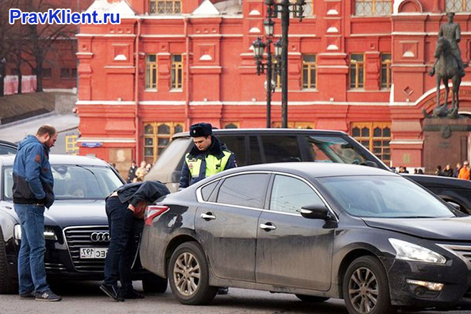 Сотрудник ГИБДД досматривает машину